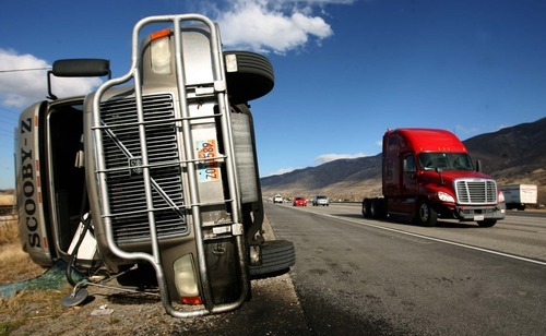 Leah Hogsten | The Salt Lake Tribune  
A semitruck toppled in the wind on I-15 in Centerville. Hurricane-force winds, in places topping 100 mph, ripped through Utah on Thursday, overturning semi-trailer rigs on Interstate 15, toppling trees and triggering widespread power outages affecting nearly 50,000 homes and businesses.