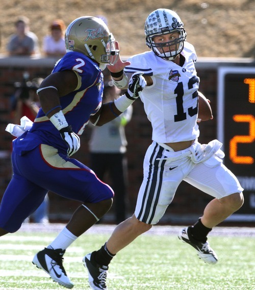 Rick Egan  | The Salt Lake Tribune 

Brigham Young Cougars quarterback Riley Nelson (13) stiff arms Tulsa Golden Hurricane linebacker DeAundre Brown as he runs the ball for the Cougars, in football action, BYU vs. Tulsa, in the Armed Forces Bowl, in Dallas, Texas, Friday, December 30, 2011