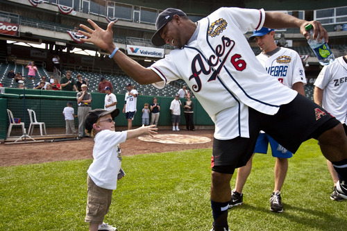 Chris Detrick | The Salt Lake Tribune 
Lincoln Jeppesen, 11, of Salt Lake City, celebrates with Reno's Tony Abreu after scoring a run during the Miracle League Baseball Game at Spring Mobile Ballpark in Salt Lake City on Tuesday July 12, 2011.