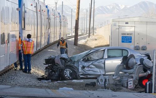 Paul Fraughton | The Salt Lake Tribune
UTA  workers investigate the scene of a TRAX collision with a car at the crossing at 8600 South and 3200 West on Tuesday, Jan. 3, 2012.