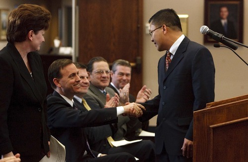 Leah Hogsten | The Salt Lake Tribune  
West Valley City new council member Tom Huynh gets a hearty handshake from Mayor Mike Winder during the new council members swearing-in, Tuesday, January 3, 2012. Huynh was one of three new council members.