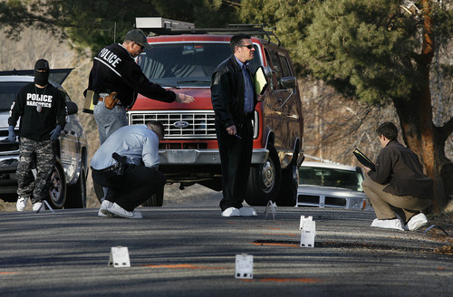 Scott Sommerdorf  |  The Salt Lake Tribune             
Police investigators look at the area on Jackson Street outside the home at 3268 Jackson St. in Ogden, Thursday, January 5, 2012. There were numerous evidence markers on the street marking the spot of bullet casings or other evidence. Five police officers were injured and one killed in a firefight during a drug raid Wednesday night.