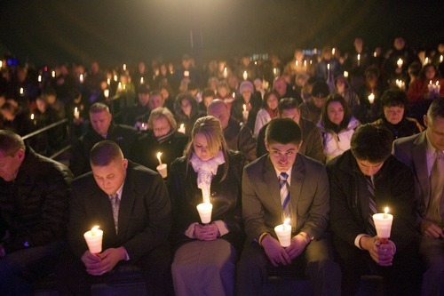 Kim Raff I The Salt Lake Tribune
During a candle light vigil the Francom family bows their head in a moment of silence for Agent Jared Francom, who was killed, and the five other officers who were wounded in a gun battle with a suspect the night before, at the Ogden Amphitheater in Ogden, Utah on January 5, 2012.
