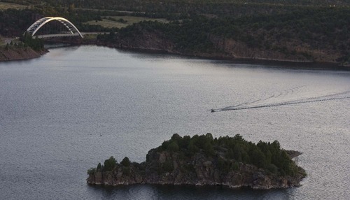Paul Fraughton  |  The Salt Lake Tribune. A boater  cuts across  Flaming Gorge Reservoir near the dam site on  Wednesday  August 17, 2011. A Colorado developer wants to withdraw water from the Green River and Flaming Gorge Reservoir, which straddles the Wyoming-Utah state line.
