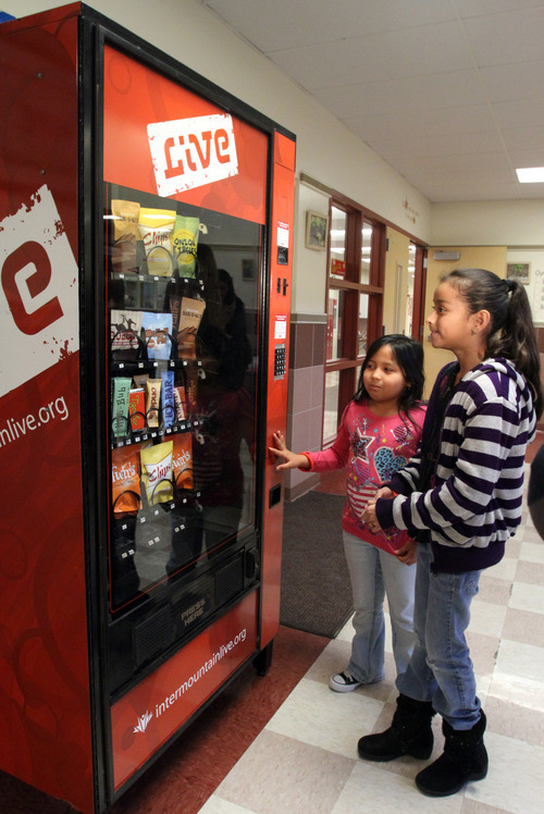 Rick Egan  | The Salt Lake Tribune 

Marlen Diaz, (eft) and  Karen Canteres (right) check out a fake vending machine at Rose Park Elementary, Thursday, January 19, 2012. Intermountain Healthcare is putting the fake vending machine in some schools to help educate children about nutrition.