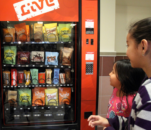 Rick Egan  | The Salt Lake Tribune 

Marlen Diaz, (eft) and  Karen Canteres (right) check out a fake vending machine at Rose Park Elementary, Thursday, January 19, 2012. The machine, which talks, is designed to help educate kids about making good food choices.