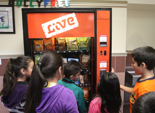Rick Egan  | The Salt Lake Tribune 

Students check out a fake vending machine at Rose Park Elementary, Thursday, January 19, 2012. When kids push a button, the machine talks to them in a playful way to discourage them from eating junk food.