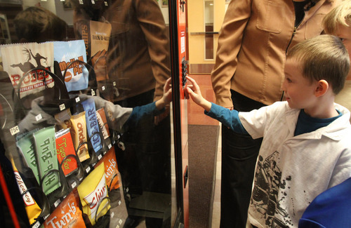 Rick Egan  | The Salt Lake Tribune 

First Grader, Noah Wilson pushed a button of a fake vending machine at Rose Park Elementary, Thursday, January 19, 2012. Instead of dispensing food, the machine spits out humorous comments intended to make kids think about what they eat.