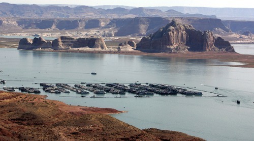 Boaters are dwarfed by the sandstone walls of Lake Powell, The lighter colors of the shore denote the low water level.  7/21/06 Jim Urquhart/Salt Lake Tribune