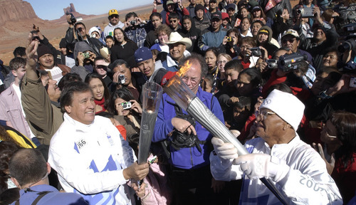 Al Hartmann | Tribune file photo
Massess of people, mostly Navajo, crowd around Willfred Billey, right, a Navajo code talker from Farmington, N.M., as he lights the Olympic torch of legendary runner. An estimated 10,000 fans attended the run through Monument Valley in the Navajo Tribal Park.