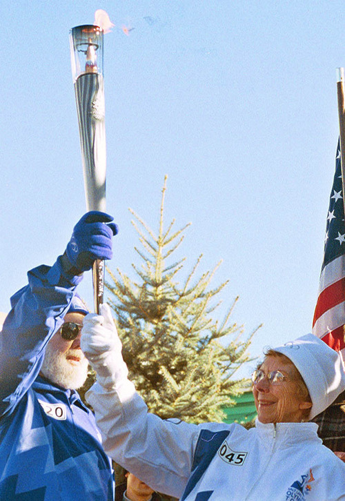 Thomas Burr | Tribune file photo
Orem's Donley Despain, left, helps hold the torch with Parowan's Carol Wright, a 93-year-old cousin of Utah's first gold medalist, Alma W. Richards. Wright carried the Olympic flame to Richards' boyhood home during the celebration in Parowan.