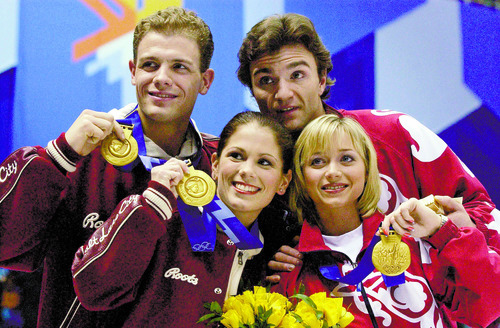 Tribune file photo
The unprecented co-gold medalists in the pairs figure skating competition from Canada and Russia pose together after a judging scandal.