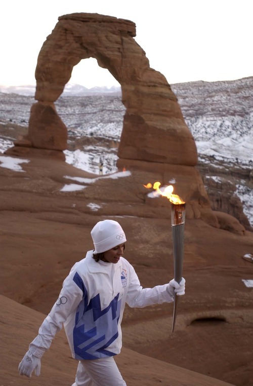 Tribune file photo
Stephanie Laree Spann carries the Olympic torch from Delicate Arch in Arches National Park, following a sunrise ceremony and blessing performed by her grandfather.