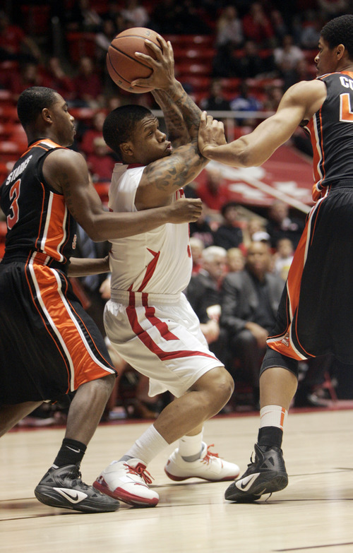 Utah's Kareem Storey, center, is surrounded by Oregon State players Ahmad Stark,left, and Devon Collier during the first half of an NCAA college basketball game at the Huntsman Center in Salt Lake City, Utah on  Saturday Feb. 4, 2012. (AP Photo/The Salt Lake Tribune,Kim Raff)