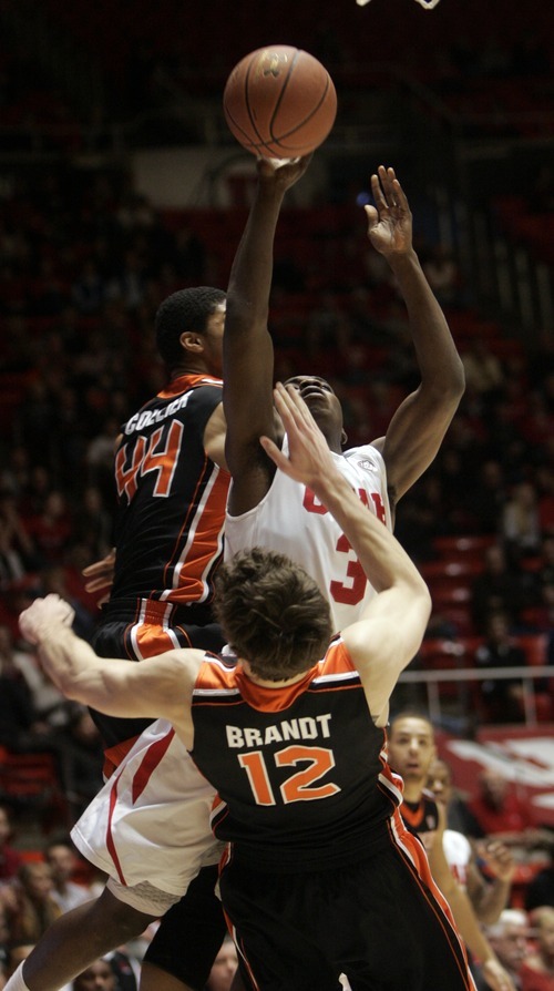 Kim Raff |The Salt Lake Tribune
University of Utah player Anthony Odunsi takes a shot past Oregon State players (left) Devon Collier and Angus Brandt during the first half at the Huntsman Center in Salt Lake City, Utah on February 4, 2012.