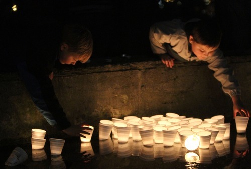 Rick Egan  | The Salt Lake Tribune 

Five year-old Wyatt Brown, Tacoma, and Jacob Craven, 8 drop a candles into  McKinley Pond during a vigil  at McKinley Park in Tacoma, Monday, February 6, 2012.  Between 300 and 400 people attended the vigil.
