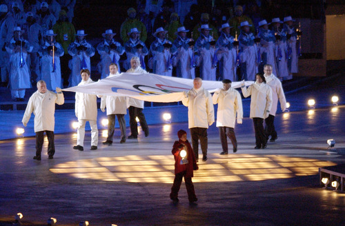 Steve Griffin | Tribune file photo
A child with a lantern leads global luminaries John Glenn, Desmond Tutu, Cathy Freeman, Kazuyoshi Funaki, Lech Walesa, Jean-Michel Cousteau, Jean-Claude Killy and Steven Spielberg into Rice-Eccles Stadium while carrying the Olympic flag during the Opening Ceremony.