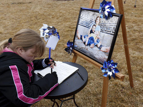 Trent Nelson  |  The Salt Lake Tribune
Wendy Morgan writes her thoughts in a book at a community pinwheel vigil for Charlie and Braden Powell in the Municipal Gardens Playground Thursday in Ogden. The event was put on by Prevent Child Abuse Utah.