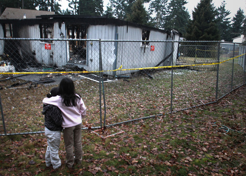 Rick Egan  | The Salt Lake Tribune 

Two young girls hug Feb. 8, 2012, as they look at the charred Graham, Wash., home where Josh Powell took his life and those of his children, Charlie and Braden. Parents are struggling with how -- and whether -- to explain this crime to their young ones.