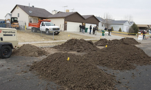 Paul Fraughton | The Salt Lake Tribune.
Mounds of dirt, removed from the back yard of a Roy house, are piled on the street as police officers investigate the scene at a home in Roy where a body was found buried in the back yard.
 Thursday, February 9, 2012