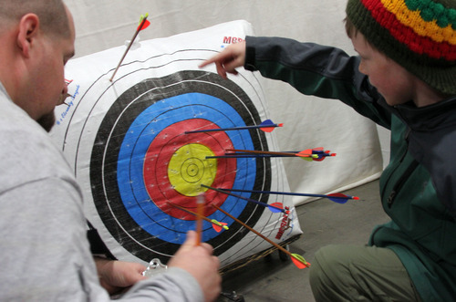 Francisco Kjolseth  |  The Salt Lake Tribune
Ben Lowder with the Utah Bowmen's Association helps Isaac Zierenberg, 9, of Heber City count up his shots during the Utah State National Archery in the Schools Tournament. The tournament run by the Utah Division of Wildlife, took place at The Salt Palace Convention Center on Saturday as part of the Western Hunting and Conservation Expo.