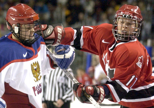 Ryan Galbraith | Tribune file photo
Canada's Danielle Goyette shoves Russia's Olga Permyakova during a preliminary-round women's hockey game at the E Center in West Valley City.