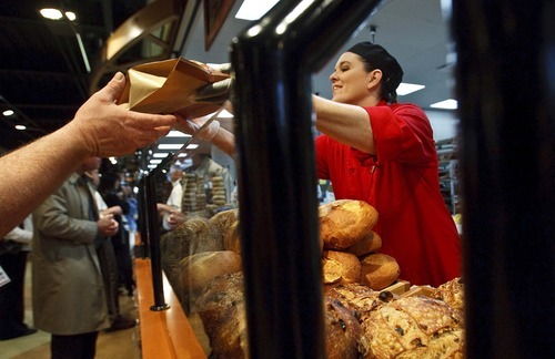 Leah Hogsten  |  The Salt Lake Tribune
Artisan bread tech Lora Powell hands out free loaves of bread on Wednesday during the opening of the new Harmons grocery store  in downtown Salt Lake City. The store at 100 S. 135 East was built on two levels. A 50,000-square-foot ground level features a large produce department and meat counter with fresh fish. On the 18,000-square-foot mezzanine there is a deli with a seating capacity for about 300 customers.