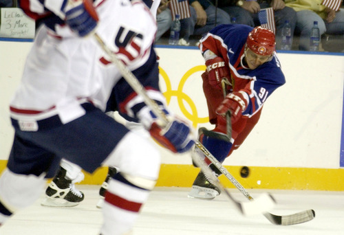 Ryan Galbraith | Tribune file photo
Russia's Sergei Fedorov passes past American defenders during a 2-2 tie in a preliminary-round men's hockey game at the E Center in West Valley City.