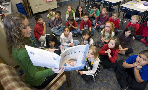Al Hartmann  |  Tribune file photo   
Second-grade teacher Meghan Dinger at Gerald Wright Elementary School in West Valley City reads to students in 2009. She gathered a bunch of books and placed them under a small Christmas tree in her classroom. During reading time, Dinger selects a student's name out of a small jar. The selected student gets to pick a gift from under the tree to open (each student gets a turn throughout the month). The book is then read aloud and placed in the classroom library.