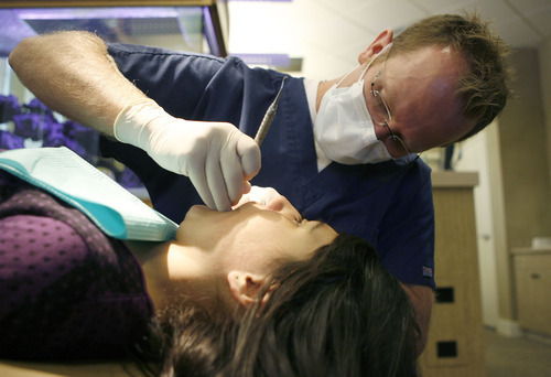 Francisco Kjolseth  |  Tribune file photo
Dr. Nathan Stevenson works on a patient in 2011.