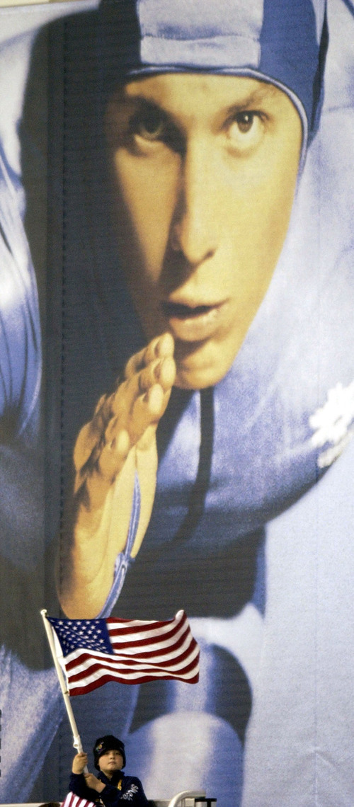 Steve Griffin | Tribune file photo
A young fan waves an American flag in front of the giant mural of a speedskater on the wall of the Utah Olympic Oval.