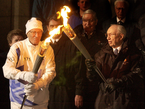 Mormon apostle Neal A. Maxwell lights his torch from the one held by LDS Church President Gordon B. Hinckley during the start of the 2002 Salt Lake Olympics.