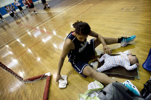 Kim Raff |The Salt Lake Tribune
Ta'a Tuinei takes a break from running drills to change her son Tereinga Tuinei's diaper while at practice at Skyline High School in Salt Lake City, Utah on February 9, 2012.