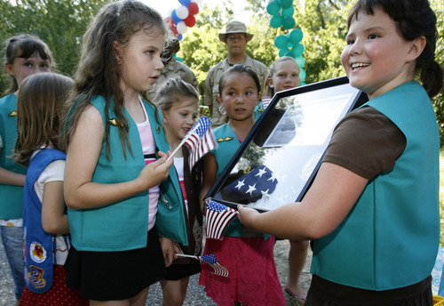 Tribune file photo

Ashley Wiltsie (left, holding flag), Amanda Wiltsie, Ciara Sase and Susie Eberle (far right) are excited to have been awarded a flag and plaque from the 4th Air Craft Maintenance Division of the 388th AMXS Unit. Girl Scout Troop 76 celebrated their bridging ceremony from Brownies into Junior Girl Scouts in June 2006. The bridging ceremony celebrates what the girls have accomplished from one Girl Scout  age level to the next.  For this troop, the bridging ceremony was extra special as two members of the Hill Air Force Base's 388th AMXS unit will be conducting a flag ceremony with the girls and present them with a U.S. flag that flew in Iraq on one of their missions.