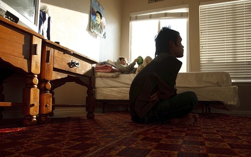 Leah Hogsten  |  The Salt Lake Tribune

KaPaw Htoo sits on his family's living room floor, which is also his bedroom. A younger brother relaxes on KaPaw Htoo's bed. To cut down on rent, the family of 7 shares their Heber City home with a young couple. Nearly 60 Burmese refugees have moved to Heber for job opportunities at a dry-cleaning plant.