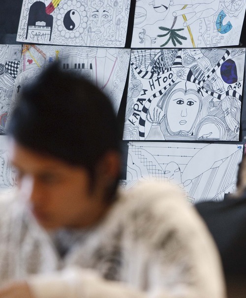 Leah Hogsten  |  The Salt Lake Tribune
One of KaPaw Htoo's drawings hangs behind him as he works on a new assignment in art class.  In June, he moved to Utah from a refugee camp in Thailand, where he was born to Karen parents fleeing violence in nearby Burma. He did not speak any English when he arrived, but his vocabulary is growing with a class schedule that focuses heavily on learning English. Art is one of three class periods not devoted to English.