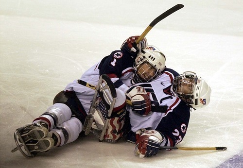 Leah Hogsten | Tribune file photo
USA'S Lonnie Hannah (left) celebrates Joe Howard's score early in the game. USA defeated Norway 4-3 in a shoot out for the gold medal during Ice Sledge Hockey championship game March 15, 2002, at the E Center.