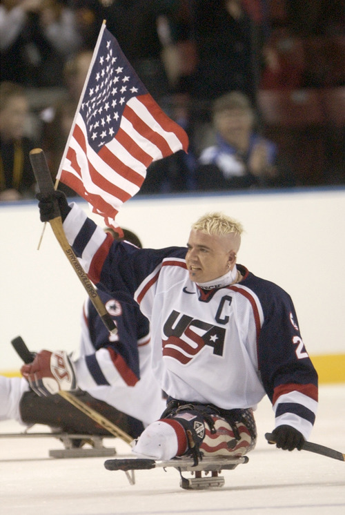 Steve Griffin | Tribune file photo
USA team captain Joe Howard carries the flag around the rink after the USA defeated Norway for the gold medal at the E Center on March 15, 2002.