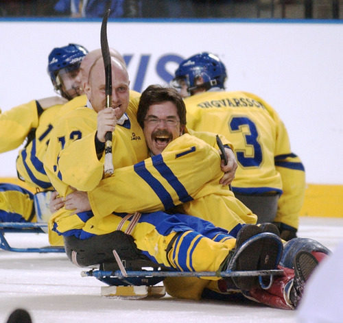 Steve Griffin | Tribune file photo
Frank Pedersen (right) hugs teammate Joakim Larsson after  Sweden defeated Canada for the bronze medal in the Paralympic Sledge Hockey game at the E Center on March 15, 2002.