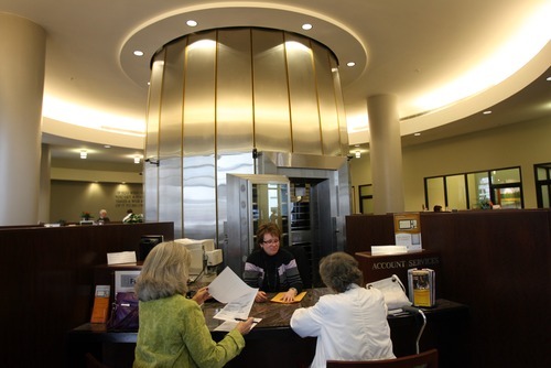 Kim Raff | The Salt Lake Tribune 
Charlotte Hager, of account services, helps Kathie Greeno, left, and Barbara Roberts at Zion Bank in Salt Lake City on Wednesday. Zions Bank has passed a 
