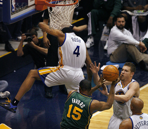 Scott Sommerdorf  |  The Salt Lake Tribune             
Utah center Derrick Favors came away holding his left shoulder after  this play where Golden State's Brandon Rush came down on him in this battle to block Favors' shot during first half play. The Utah Jazz trailed the Golden State Warriors 51-46 at the half at Energy Solutions Arena, Saturday, March 17, 2012.