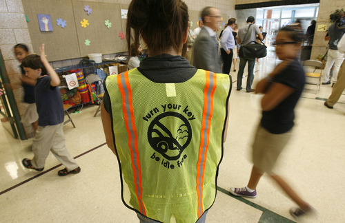 Francisco Kjolseth  |  Tribune file photo
Dusty Bagshaw, PTA president at Mountain View Elementary, wears the vest she wears during kid drop-off and pick-up as a way to promote being idle free after a press conference launching Idle Free Awareness Month at the school in 2011. The campaign promotes decreasing excess exhaust contributing to smog by not idling in cars.