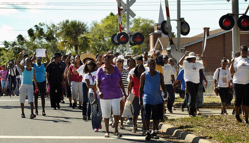 People march up South Street towards the Titusville Courthouse on Sunday, March 18, 2012, in Titusville, Fla. A rally was held demanding justice for Trayvon Martin, a black Florida teenager fatally shot by a white neighborhood watch volunteer. No charges have been filed in the February death. (AP Photo/Florida Today, Craig Rubadoux) NO SALES; MAGS OUT