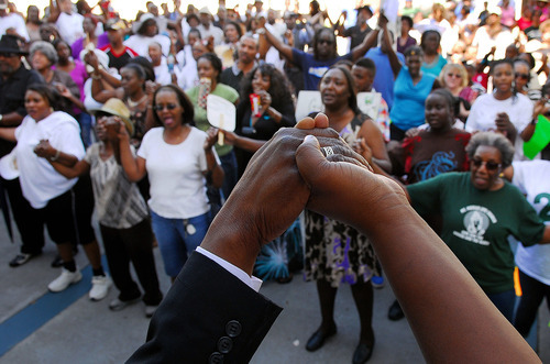 Rev. Glenn Dames, senior pastor at St. James AME Church, leads people in a prayer at the Titusville Courthouse on Sunday, March 18, 2012, in Titusville, Fla. A rally was held demanding justice for Trayvon Martin, a black Florida teenager fatally shot by a white neighborhood watch volunteer. No charges have been filed in the February death. (AP Photo/Florida Today, Craig Rubadoux) NO SALES; MAGS OUT; MANDATORY CREDIT: FLORIDATODAY.COM