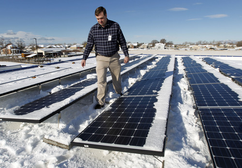 Al Hartmann  |  The Salt Lake Tribune
Quest Academy network administrator Jeff Seager checks out an array of solar collectors on the roof of the school Monday March 19 after a recent snow storm. The school also installed a 42-inch monitor inside the West Haven school to monitor the solar panels power genration and  CO2 emissions offsets.