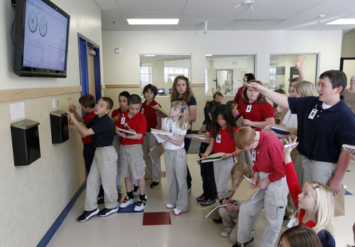 Al Hartmann  |  The Salt Lake Tribune
Quest Academy fourth grade math class studies a 42-inch monitor inside the school that reads the school's solar panels  power generation and CO2 offsets. That monitor apparently draws a lot of attention in the West Haven school by students as well as parents.