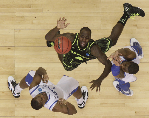 Kentucky's Marquis Teague, right, and Kentucky's Darius Miller work for a rebound with Baylor's Quincy Acy (4) during the second half of an NCAA tournament South Regional finals college basketball game Sunday, March 25, 2012, in Atlanta. (AP Photo/David J. Phillip)