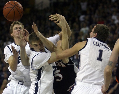 Kim Raff | The Salt Lake Tribune
Utah State University players (from left) Danny Berger, Morgan Grim, and Ben Clifford fight for a rebound with Mercer player Bud Thomas during the CIT Championship game at Utah State University in Logan, Utah on March 28, 2012.  Mercer went on to win the game 67-70.