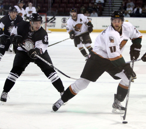 Rick Egan  | The Salt Lake Tribune 

John Armstrong (11) passes the puck for the Grizzlies, as Adam Miller (81) defends for the Wranglers, in ECHL action Grizzlies vs. The Las Vegas Wrangles, at the Maverick Center,  Monday, April 2, 2012.