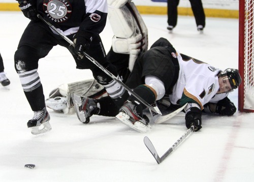 Rick Egan  | The Salt Lake Tribune 

The Grizzlies' Jeff LoVecchino (18) lands on Wrangler goal keeper Mitch Okeele (1) as he tries to get the puck along with Wrangler, Channing Boe (25) for the puck, in ECHL action Grizzlies vs. The Las Vegas Wrangles, at the Maverick Center,  Monday, April 2, 2012.